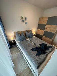 a bedroom with a large bed with blue pillows at Ponton Apartman Alsóőrs in Alsóörs +27 photos