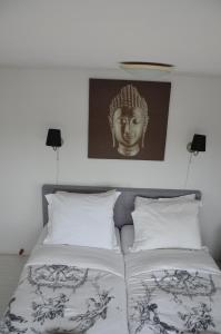 a bedroom with two beds and a picture of a headboard at Pension 't hofje 350 meter van het strand in Noordwijk aan Zee