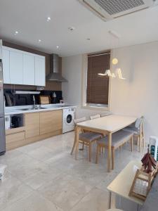 a kitchen with a table and chairs and a kitchen with white cabinets at Ocean View Private Pool Villa in Jeju