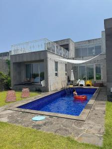 a swimming pool in front of a house at Ocean View Private Pool Villa in Jeju