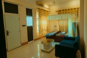a living room with a couch and a bed and a door at Korogwe Comfort Hotel in Nkunjila