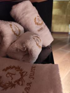 a stack of folded white towels with writing on them at Alba Suites in Vlorë