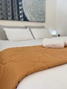 a bed with a brown blanket on top of it at LAC Holiday Apartment in Calceranica al Lago