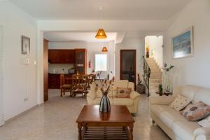 een woonkamer met een bank en een tafel bij Peyia Villas Cyprus in Peyia
