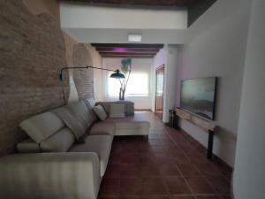 a living room with a couch and a tv at La Bellamar - Apartamento en primera línea mar- in Premiá de Mar