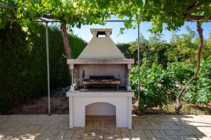 een buitenoven op een terras onder een boom bij Peyia Villas Cyprus in Peyia