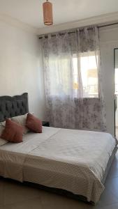a bedroom with a large bed with a window at Holidays in Martil - Beach, comfort and safety in Martil