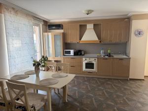 a kitchen with wooden cabinets and a table with chairs at Admiral Plaza Apartments in Sunny Beach