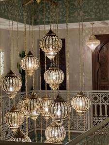 ein paar Kronleuchter hängen an einem Spiegel in der Unterkunft Riad Noon in Marrakesch