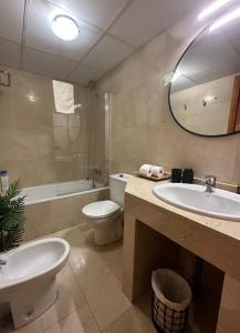 łazienka z umywalką, toaletą i lustrem w obiekcie Apartamento Calle Varela Centro w Grenadzie