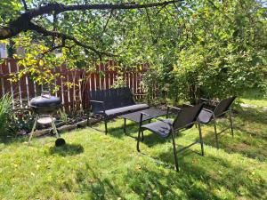 a group of chairs and a grill in a yard at Villa Manna - Charming Flat in a Historic House in Tallinn
