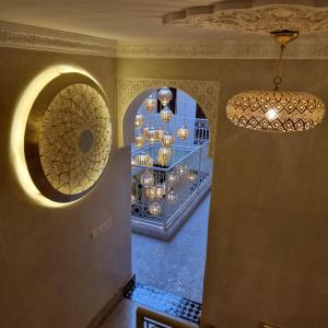 ein Zimmer mit einem Kronleuchter und ein Zimmer mit einem Regal mit Kronleuchter in der Unterkunft Riad Noon in Marrakesch