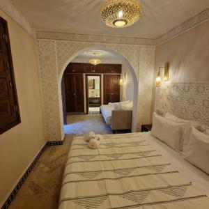 ein Schlafzimmer mit einem Bett, auf dem ein Teddybär liegt in der Unterkunft Riad Noon in Marrakesch