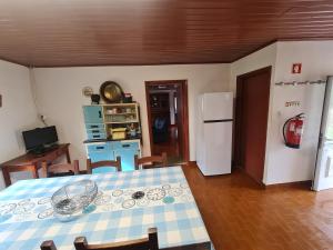 a kitchen and dining room with a table and a refrigerator at Casa de Cabecinho- Albufeira do Azibo in Bragança