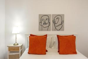 Un dormitorio con una cama con almohadas naranjas. en Papoa Beach House, en Peniche 22 fotos más
