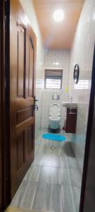 a bathroom with a toilet and a sink and a door at Mission Inn in Kigali