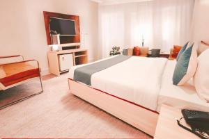Un dormitorio con una gran cama blanca y un televisor. en Hotel Star Pride Plaza Near Delhi Airport With - Free Airport Pickup, en Nueva Delhi