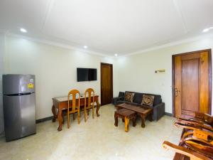 a living room with a couch and a table and chairs at Siem Reap Local Stay in Phumĭ Réach Born