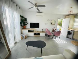 a living room with a ceiling fan and a table at Calpe bungalow adosado piscina jardin barbacoa aire centrico moderno in Calpe