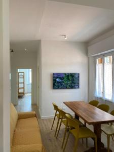 une salle à manger avec une table en bois et des chaises jaunes dans l'établissement La Casa di Didi, à Porto Azzurro