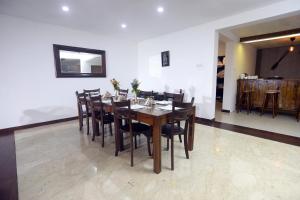a dining room with a wooden table and chairs at Richmond Hill Estate bungalow in Kandy