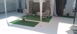 a rendering of a room with two chairs and plants at Spacious seaside house in Nea Makri in Nea Makri