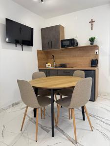 a kitchen with a wooden table and chairs at Kozy Apartments in Međugorje