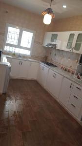 a kitchen with white cabinets and a wooden floor at Bizerte ,Tunisa with 2 rooms in Les Andalous +16 photos