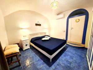 a bedroom with a bed and a chair in it at Ely House Costa d'Amalfi Casa Vacanze in Albori