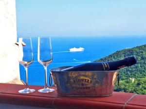 two wine glasses and a container with a bottle of wine at Ely House Costa d'Amalfi Casa Vacanze in Albori