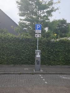 a parking meter with a parking sign on a street at Ser's Studio Orange in Maastricht