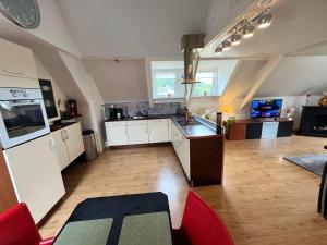 a large kitchen with white cabinets and a counter top at Villa Grenszicht in Nispen