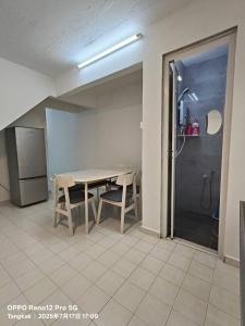 a dining room with a table and chairs and a refrigerator at TANGKAK HOMESTAy in Tangkak