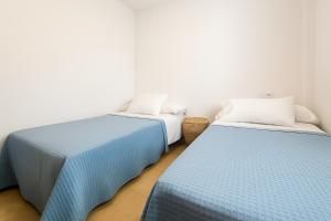 two beds sitting next to each other in a room at Apartamento Ría Punta Umbría in Punta Umbría