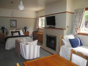 a living room with a bed and a fireplace at Cheltenham House in Hanmer Springs