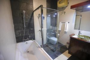 a bathroom with a shower and a toilet and a sink at Richmond Hill Estate bungalow in Kandy +13 photos