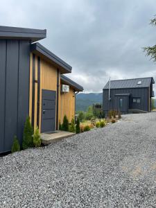 a home with a gravel driveway and two buildings at Sky Space Slavske Котеджі в горах з теплим басейном in Slavske