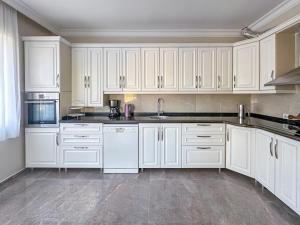 a white kitchen with white cabinets and appliances at Urla Villa in Urla