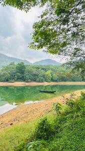 a boat sitting on the shore of a body of water at Fennys Nook in Trivandrum +31 photos