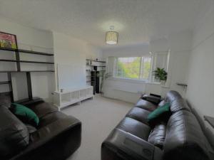 a living room with a leather couch and a window at 4 to 5 Bedroom beautiful holiday home London sleeps 9-central Links in London