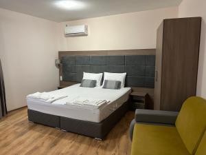 una camera da letto con un letto grande e una sedia di Судио Диксан a Pomorie