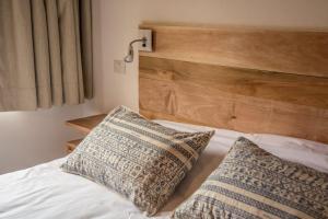 a bedroom with a bed with two pillows on it at Altos de la Montaña in San Martín de los Andes