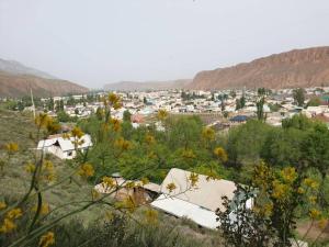 a town in the middle of a field with buildings at Дом на скале in Naryn