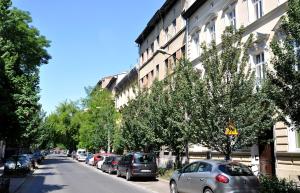 una calle con coches estacionados en el lateral de un edificio en Angel House Aparthotel, en Cracovia