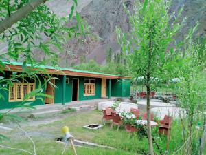 a house with a table and chairs in front of it at Hotelgreenland in Skardu