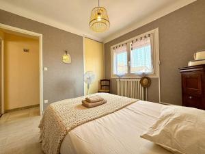 a bedroom with a large white bed with two towels on it at L'Escapade du Midi in La Celle-sous-Gouzon