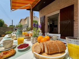 a table with bread and oranges and glasses of orange juice at L'Escapade du Midi in La Celle-sous-Gouzon