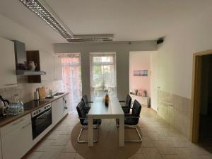 a kitchen with a white table and black chairs at Birkenwald in Eilenburg