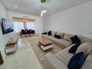 a living room with a couch and a table at Bel apprt a tanger beach in Tangier