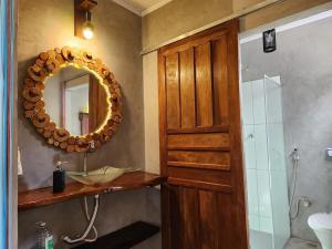 a bathroom with a mirror and a sink and a shower at Welcome to Sítio Arcanjos in Alto Paraíso de Goiás +45 photos